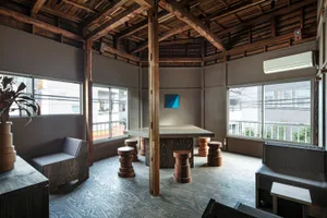 Modern industrial living room with wood furniture and exposed wooden beams on the ceiling.
