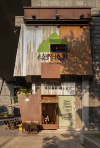 戶外用餐區設有金屬包覆遮篷與招牌，屬於市場小吃餐廳。