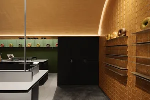 A modern bakery interior with wooden tiles and doughnuts on display.