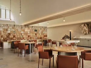 Modern restaurant dining room with wooden tiles and contemporary furniture.