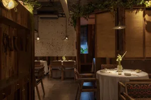 Industrial-style restaurant interior with wooden elements and greenery.