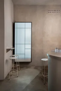 A minimalist bar area with concrete and glass materials.