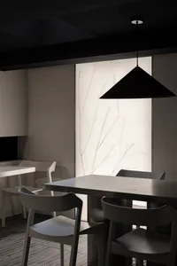 Modern minimalist restaurant dining room featuring wooden tables and chairs.