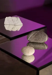A modern glass table with decorative stones placed on it, creating a balanced and minimalist display.