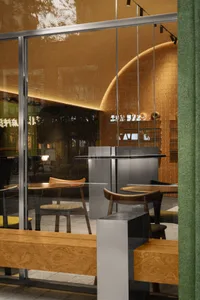A modern coffee shop interior with wooden furniture and metal tables