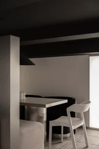 A minimalist modern restaurant setting featuring metal furniture and a sleek, clean aesthetic.