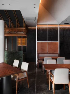 Modern restaurant interior featuring wooden tables and marble accents.