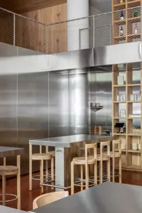 Industrial-style bar counter made of metal, with high stools and a metallic surface.