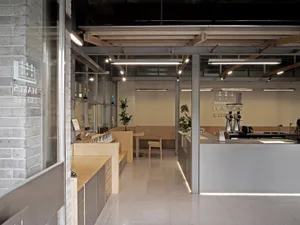 Modern industrial coffee shop with concrete and steel materials and minimalist design.