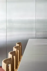 Modern interior featuring metallic furniture chairs arranged around a sleek metallic dining table.