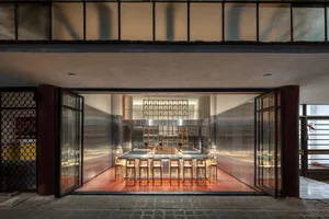 A modern minimalist cafe interior with a metal frame and wooden elements.