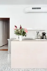 Floral arrangement on a modern restaurant countertop with concrete material and minimalist design.