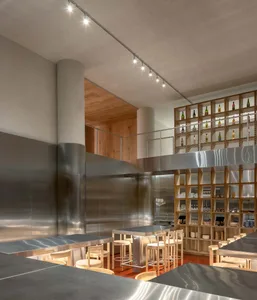 Interior of a modern minimalist restaurant with metal walls and bar stools