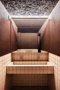 Public toilet with modern design featuring concrete walls and tiled floor