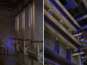 Various metal pipes and beams form the seating area and decor in an industrial-themed bar.