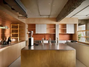 Modern industrial coffee shop featuring a metal-clad matte brass kitchen counter.