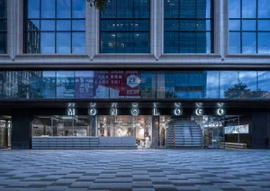 Modern storefront with glass facade, metal railings, and concrete elements.