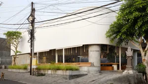 Modern, minimalist cafe exterior with concrete and glass materials, featuring clean lines and a sleek design