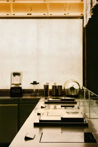 A sleek, modern coffee bar featuring transparent glass and metal elements.
