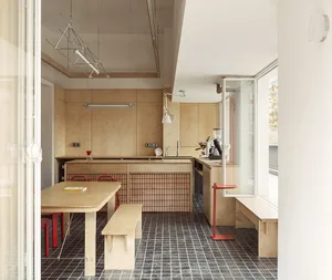 A minimalist kitchen with wooden furniture and a small window.