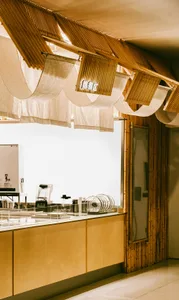 A cozy coffee shop interior with a wooden counter adorned with cloth elements.