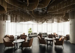 A modern lobby interior with a wave-shaped ceiling made of textile and metal materials.