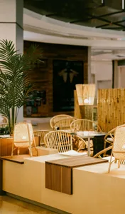 Modern restaurant interior with wooden furniture and lighting fixtures.
