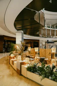 A tropical-themed restaurant interior with bamboo planters and woven furniture