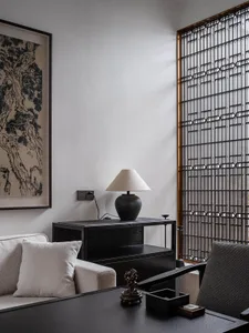 A modern minimalist living room featuring black furniture and neutral tones.