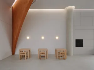A minimalist room with wooden furniture and concrete flooring.
