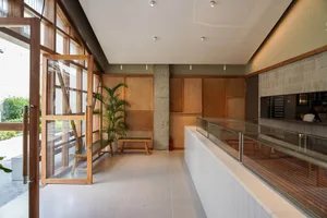 Modern coffee shop interior with natural light, wood accents, and glass barriers.