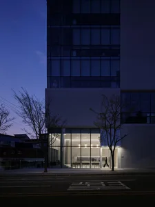 A modern storefront with glass windows and illuminated interior at night.