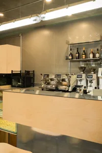 A coffee shop interior with a wood and metal bar counter.