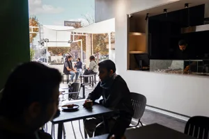 A modern cafe space with concrete seating, industrial-style design, and minimalist aesthetic.