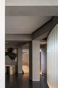 A modern office space featuring concrete columns and natural light.