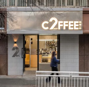 A modern retail storefront with metal boards and large glass windows.