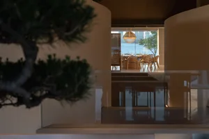 Modern residential interior with large glass windows overlooking a stunning coastal view.