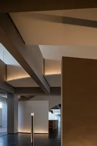 Minimalist interior space with concrete walls and beams.