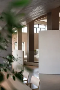 Minimalist modern living room with concrete flooring and glass walls.