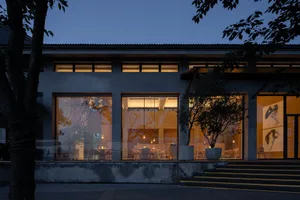 Modern restaurant exterior with concrete frame and glass windows at night