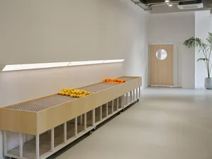 Industrial retail display featuring wood shelves filled with fruit in a minimalist space.