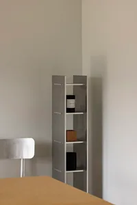 A minimalist concrete shelving unit with a sleek, modern design, featuring geometric angles and a muted, industrial aesthetic