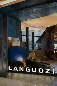 A modern restaurant interior featuring a large metallic apple sculpture and illuminated signage.