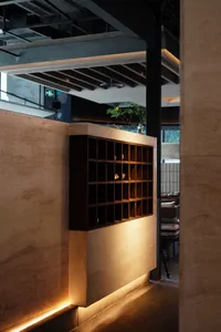 A modern restaurant interior featuring wooden shelves and warm lighting.