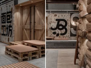 Industrial design restaurant interior with concrete walls, pallet seating, and steel paneling.