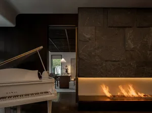 A modern living room featuring wooden flooring, stone walls, and metal accents.