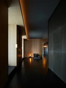 A corridor with wooden walls, a concrete vase, and a lantern.