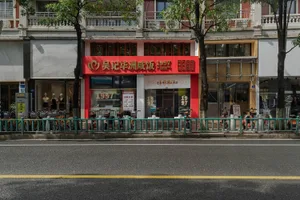 A city street scene featuring a storefront with a red awning and glass windows.