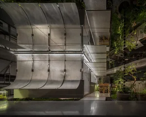 A sleek, modern restaurant interior featuring metallic and concrete materials.