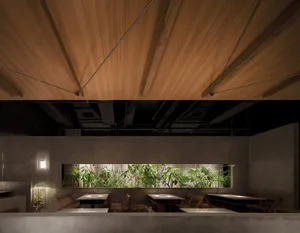 Industrial style restaurant interior showcasing concrete walls and wooden ceiling with green plants.